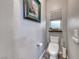 Bright powder room featuring a modern toilet, neutral walls, and wood-look flooring at 11334 Patores St, Las Vegas, NV 89141
