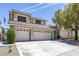 Tan two-story home with three-car garage, desert landscaping, and a tile roof at 12 Golden View St, Henderson, NV 89012