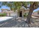 Tan two-story home with three-car garage and low maintenance desert landscaping at 12 Golden View St, Henderson, NV 89012