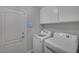 Functional laundry room equipped with a washer, dryer, and overhead cabinets at 12 Golden View St, Henderson, NV 89012