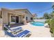 Backyard pool with lounge chairs, lush landscaping, and an outdoor patio area at 12 Golden View St, Henderson, NV 89012