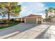 Single-story home featuring a well-manicured lawn, desert landscaping, a two-car garage, and a gated driveway at 1393 Calmview Pl, Las Vegas, NV 89110
