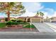 Inviting single-story home featuring a well-manicured lawn, desert landscaping, and an attached two-car garage at 1393 Calmview Pl, Las Vegas, NV 89110
