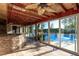 Enclosed patio with tile floors and stone bar overlooking the sparkling pool and manicured yard at 1393 Calmview Pl, Las Vegas, NV 89110