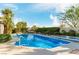 Backyard oasis features a sparkling blue pool and jacuzzi surrounded by lush landscaping at 1393 Calmview Pl, Las Vegas, NV 89110