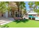 Expansive backyard featuring a pool with rock waterfall, putting green and outdoor living area at 179 Adomeit Dr, Henderson, NV 89074