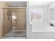 Bathroom featuring glass shower, a tub, and natural light at 179 Adomeit Dr, Henderson, NV 89074