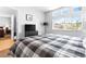 Bright bedroom featuring a large window with neighborhood views and a stylish plaid comforter at 179 Adomeit Dr, Henderson, NV 89074