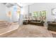 Open-concept living room with staircase, tile flooring, comfortable seating, and ample natural light at 179 Adomeit Dr, Henderson, NV 89074