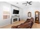 Cozy living room featuring a fireplace, plush leather sofa, and abundant natural light at 179 Adomeit Dr, Henderson, NV 89074