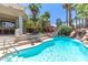 Inviting backyard pool area with rock waterfall feature, and lush tropical landscaping at 179 Adomeit Dr, Henderson, NV 89074