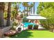 Relaxing backyard oasis with sparkling pool, rock waterfall, putting green, and covered seating area at 179 Adomeit Dr, Henderson, NV 89074