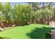 Private backyard putting green surrounded by lush greenery and mature trees at 179 Adomeit Dr, Henderson, NV 89074
