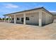 A rear view of the home featuring a large, covered back patio with tall pillars at 1800 Huckleberry St, Pahrump, NV 89048