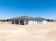 Rear exterior of a single story home with large patio and neutral color palette at 1800 Huckleberry St, Pahrump, NV 89048