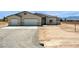 A sunny single-story home with a three-car garage, desert landscaping, and mountain backdrop at 1800 Huckleberry St, Pahrump, NV 89048