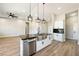 Open concept kitchen features an island with black countertops, stainless steel sink, and stainless steel dishwasher at 1800 Huckleberry St, Pahrump, NV 89048