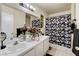Bright bathroom with double vanity, large mirrors, and shower with decorative floral curtain at 2402 Saguaro Point St, Las Vegas, NV 89115