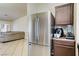 Kitchen area with stainless steel refrigerator, tile floor, and granite countertops at 2402 Saguaro Point St, Las Vegas, NV 89115