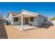 View of home's backyard including a covered patio, stucco wall, and desert landscaping at 2421 Sunrise Springs Ct, North Las Vegas, NV 89031