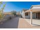 Home's spacious backyard with patio, block wall, and desert landscaping at 2421 Sunrise Springs Ct, North Las Vegas, NV 89031