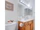 Bathroom vanity with decorative mirror and lighting, plus toilet and artwork at 2541 Desert Glen Dr, Las Vegas, NV 89134