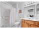 Bathroom with white shower curtain, toilet, oak vanity and bright lighting at 2541 Desert Glen Dr, Las Vegas, NV 89134
