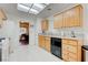 Bright kitchen with wood cabinets, white appliances, tile floors, and stone countertops at 2541 Desert Glen Dr, Las Vegas, NV 89134