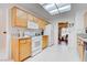 Bright kitchen featuring wood cabinets, white appliances, tile floors, and a skylight at 2541 Desert Glen Dr, Las Vegas, NV 89134