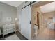 Barn door separating the main bedroom from the bathroom with tub, drawers and hardwood floors at 2555 Hampton Rd # 5104, Henderson, NV 89052