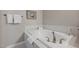 Soaking tub with white tile surround, with a bath towel and white fixtures at 2555 Hampton Rd # 5104, Henderson, NV 89052