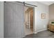 Bedroom barn door with light gray wood and a view to the bathroom with tub and vanity at 2555 Hampton Rd # 5104, Henderson, NV 89052