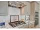 Close-up of a modern gas cooktop and range hood in a kitchen setting with granite countertops at 2555 Hampton Rd # 5104, Henderson, NV 89052