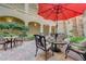 Charming outdoor patio area with multiple seating arrangements, red umbrellas and views of the building at 2555 Hampton Rd # 5104, Henderson, NV 89052