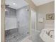 Elegant walk-in shower with marble and stone tile, with a seating bench and shower head at 2555 Hampton Rd # 5104, Henderson, NV 89052