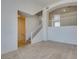 Bright, open-concept living room with neutral carpet, white trim, and stairway access at 2786 Fountain Ridge Ln, Henderson, NV 89074
