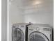 The laundry room showcases side-by-side washer and dryer units with wire shelving above at 2925 Wigwam Pkwy # 1021, Henderson, NV 89074