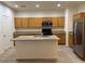 Open kitchen layout features an island, stainless appliances and wood cabinets at 3165 Beltrada Ave, Henderson, NV 89044