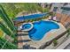 Aerial view of a backyard featuring a sparkling pool, spa, lounge chairs, and lush greenery at 3195 Hazy Hills Ave, Henderson, NV 89052
