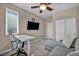 Neutral bedroom with ceiling fan, TV, desk, couch, and closet at 3195 Hazy Hills Ave, Henderson, NV 89052