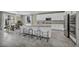 Bright kitchen featuring white cabinets, a large center island with seating, stainless steel appliances, and open dining area at 3195 Hazy Hills Ave, Henderson, NV 89052