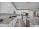 Contemporary kitchen featuring sleek stainless steel appliances, white cabinets, granite countertops, and a large island with sink at 3195 Hazy Hills Ave, Henderson, NV 89052