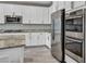 Close-up of a modern kitchen featuring stainless steel appliances, white cabinetry, and beautiful granite countertops at 3195 Hazy Hills Ave, Henderson, NV 89052