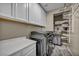Functional laundry room featuring modern appliances, white cabinets and storage racks for organized convenience at 3195 Hazy Hills Ave, Henderson, NV 89052