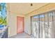 Enclosed balcony featuring tan siding, a doorway, and sliding glass doors at 3221 Jericho St # D, Las Vegas, NV 89102