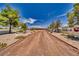 Sprawling property featuring a long driveway, mature trees, and a glimpse of the residence in the background at 3251 S Parkridge Ave, Pahrump, NV 89048