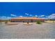 Wide rear view of the home showing covered patio and the surrounding desert landscape at 3251 S Parkridge Ave, Pahrump, NV 89048