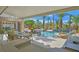 A luxury backyard with custom pool features mature palm trees, professional landscaping and a covered patio and grilling area at 328 Hedgehope Dr, Las Vegas, NV 89183
