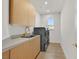 Laundry room featuring modern washer and dryer units, cabinet space, and sink at 328 Hedgehope Dr, Las Vegas, NV 89183