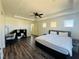 Bright bedroom with hardwood floors, ceiling fan, a desk, shelving, and a door leading to a hallway at 3508 Harbor Tides St, Las Vegas, NV 89147